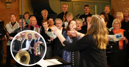 En blandad kör sjunger inomhus medan en dirigent leder; nothäften syns och en inset visar musiker med instrument..