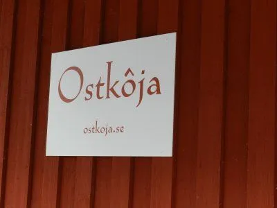 Ostkojas logga som hänger på butikens fasad. 
