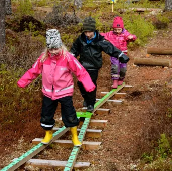 Flera barn som går balansgång på spänger.