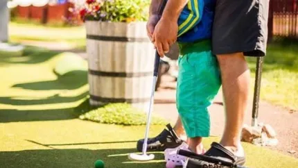 Far och son golfar tillsammans.