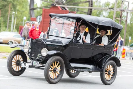 Två herrar i en äldre bil. 