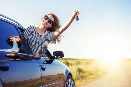 A woman in car holding o key.