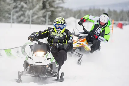 Två personer på miniskoter kommer mot kameran. 