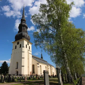 Stora Tuna kyrka, vit med högt svart torn.