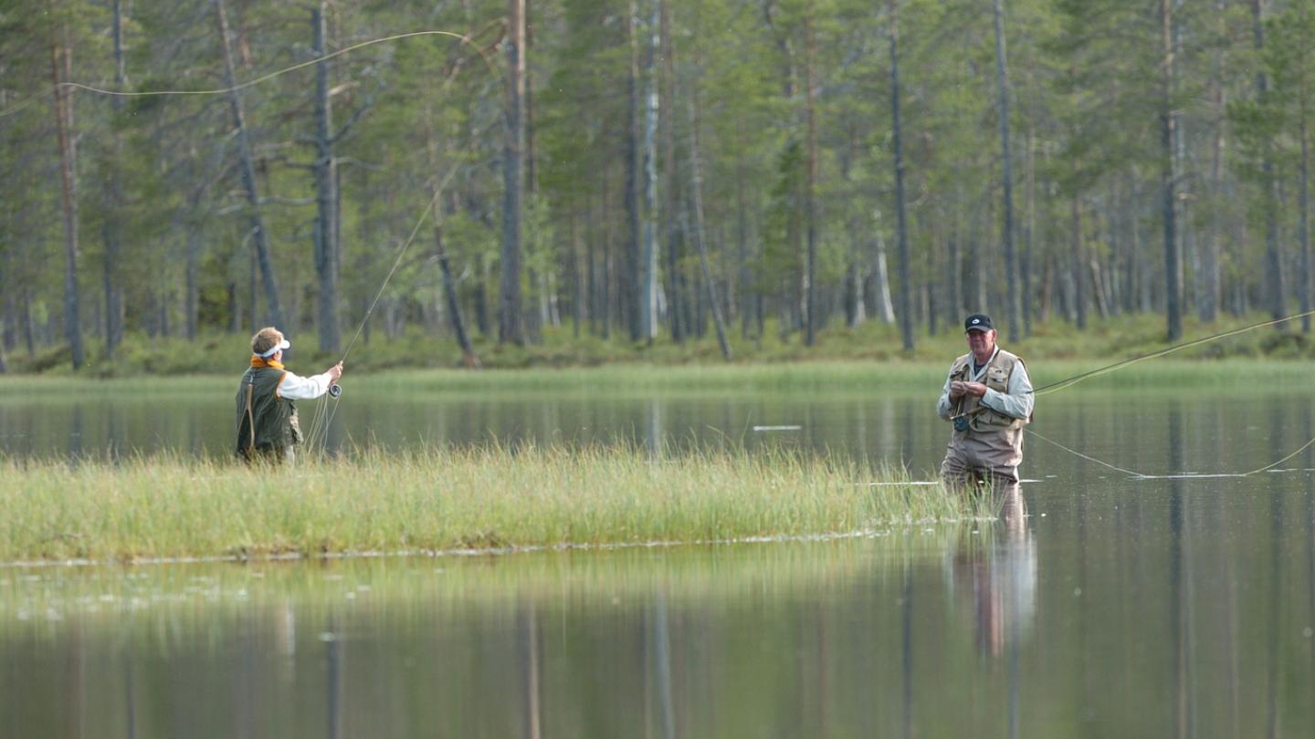 Fiskare intill kanten av en sjö.