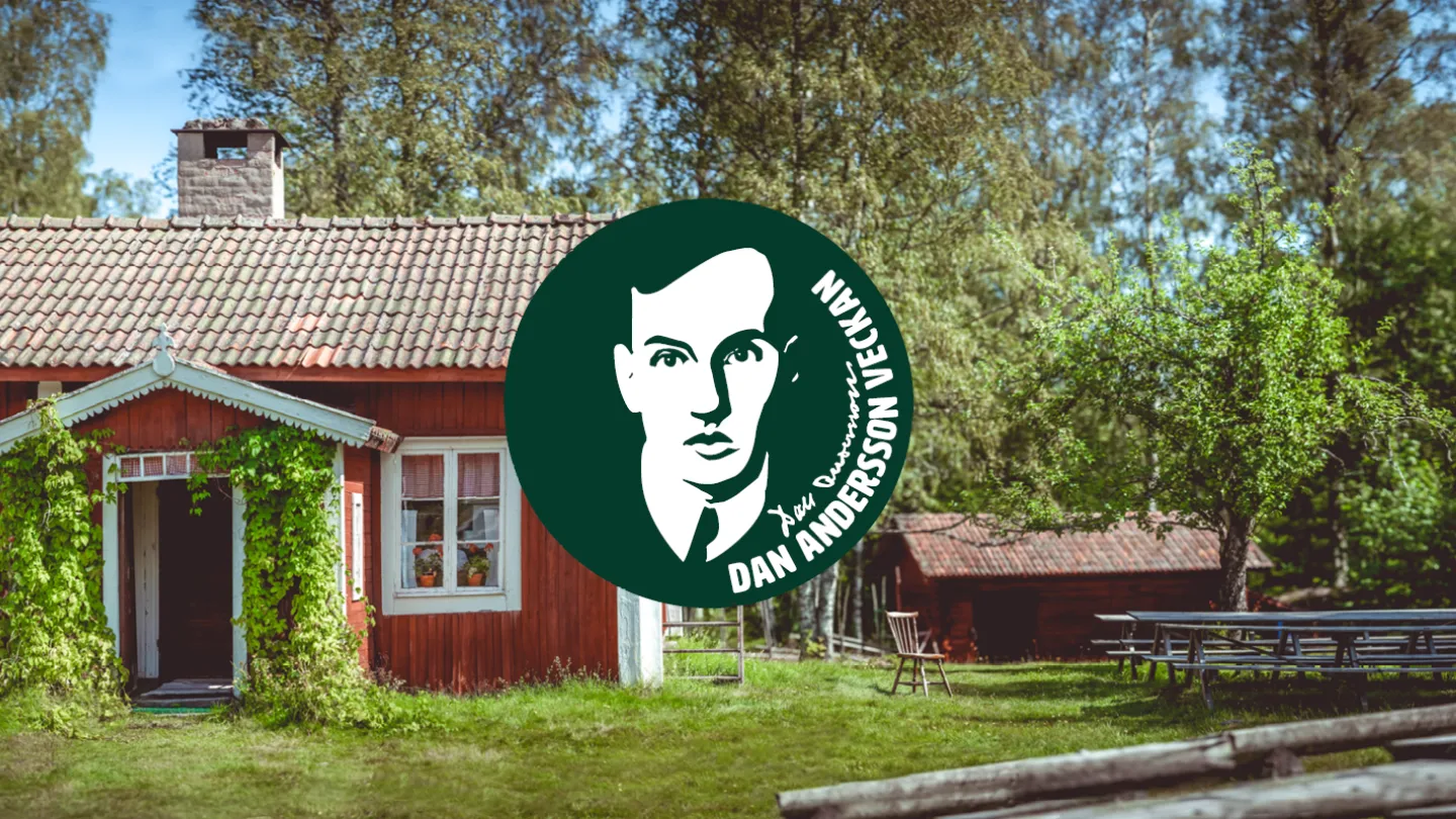 Faluröd stuga i grönskande trädgård med Dan Anderssons logga framför.