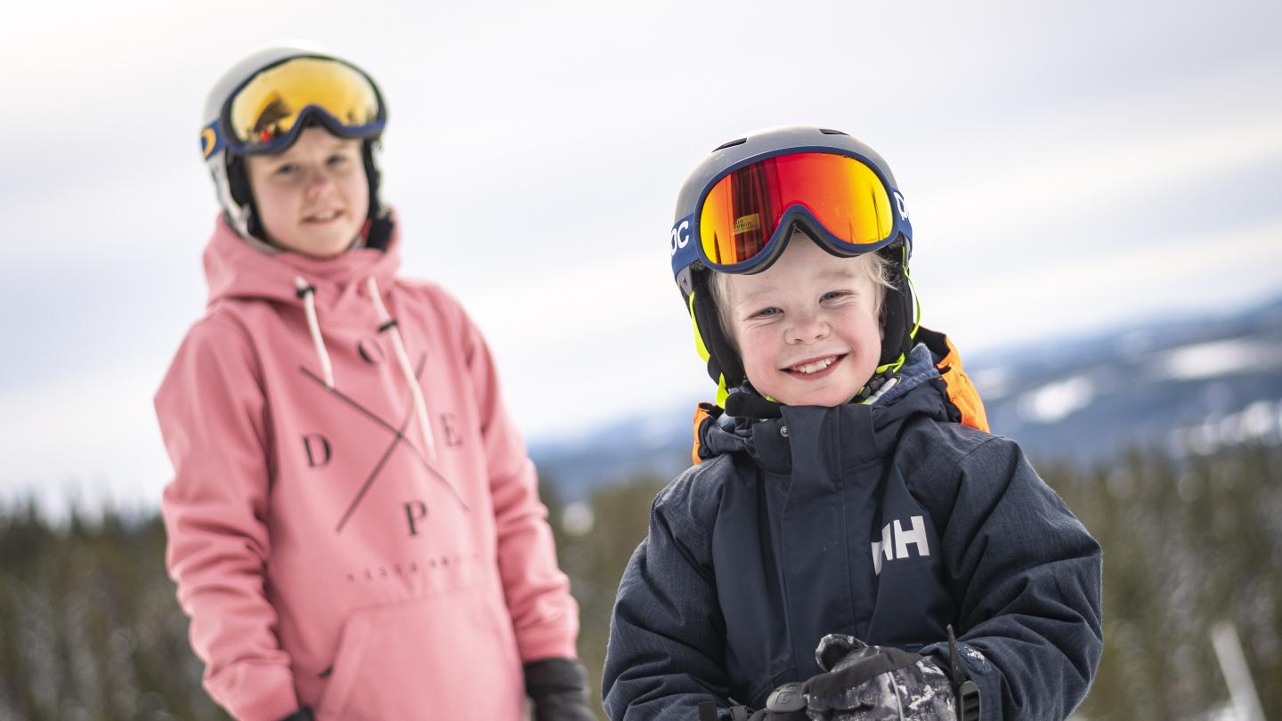 Ett par barn som ska åka alpint.