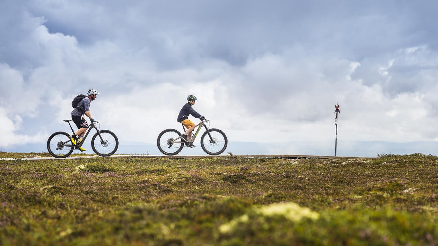 Two persons biking on a mountain.