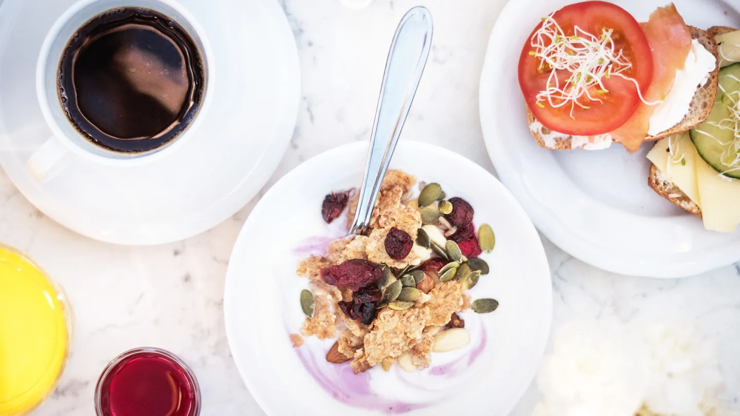Kaffekopp, skålar och fat med frukost.