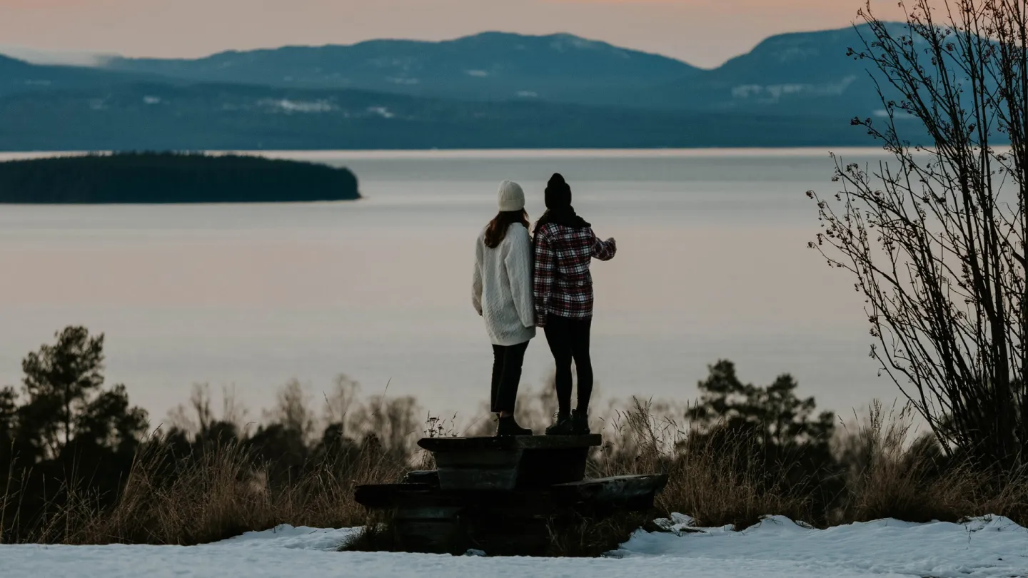 Två personer kollar mot sjön siljan.