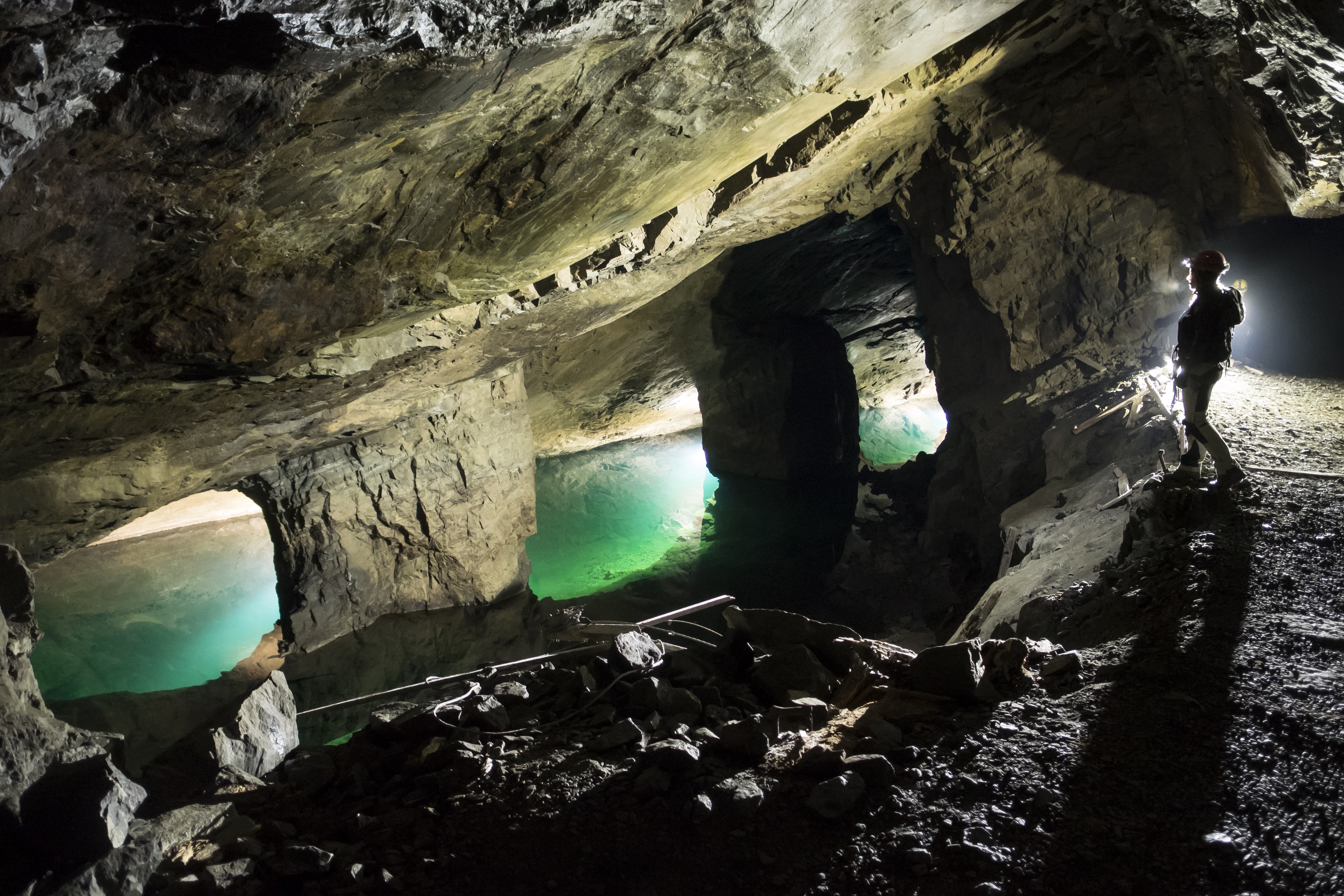 A person looking at the blue water down in the adventure mine.